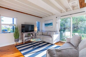 Un salon avec un téléviseur, un canapé et une grande fenêtre.