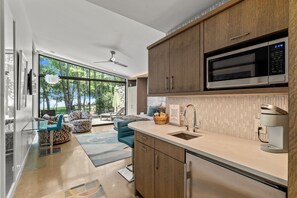 A modern kitchen with a large window, a microwave, and a coffee machine. - Lakeside Couples Retreat with Hot Tub, Lakeside Pickleball Court & More! (Malakoff)