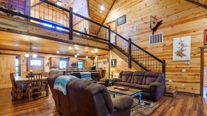 A spacious living area with a wooden interior, a staircase, and a dining area. - Whitetail Ridge Has Unbelievable Views Overlooking Beavers Bend State Park (Broken Bow)