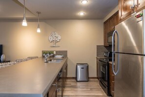 A modern kitchen with stainless steel appliances, a built-in oven, and a compact dishwasher.