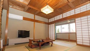 A traditional Japanese room with tatami flooring, a television, a wooden table with a tray, and shoji screens. - Yudanaka Onsen Shimaya (Yamanouchi)