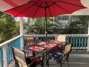 A covered outdoor dining area with a table set for four, surrounded by chairs with cushions. - Aloha Suite: Watch Whales, Breakfast included at Ala Kai Bed and Breakfast (Keaau)