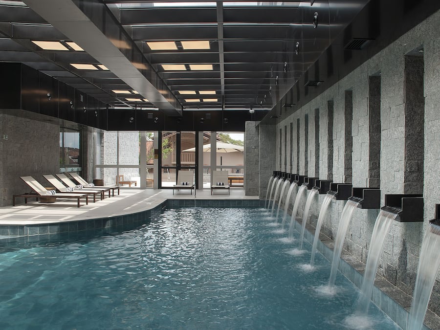 Una piscina techada, sillones reclinables de piscina