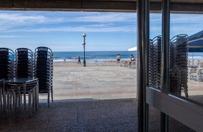 A beachside patio with stacked chairs and tables, overlooking the ocean. - Nafarroa - baskeyrentals (Zarautz)