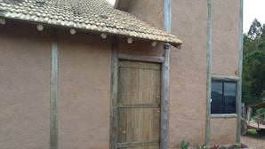 Un edificio rustico con tetto in tegole, una porta di legno e una finestra.