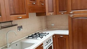 Una cocina con gabinetes de madera, una estufa a gas, un fregadero y un horno.