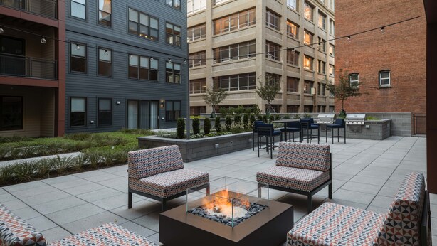 Un espace extérieur aménagé avec une terrasse, des sièges et un foyer.