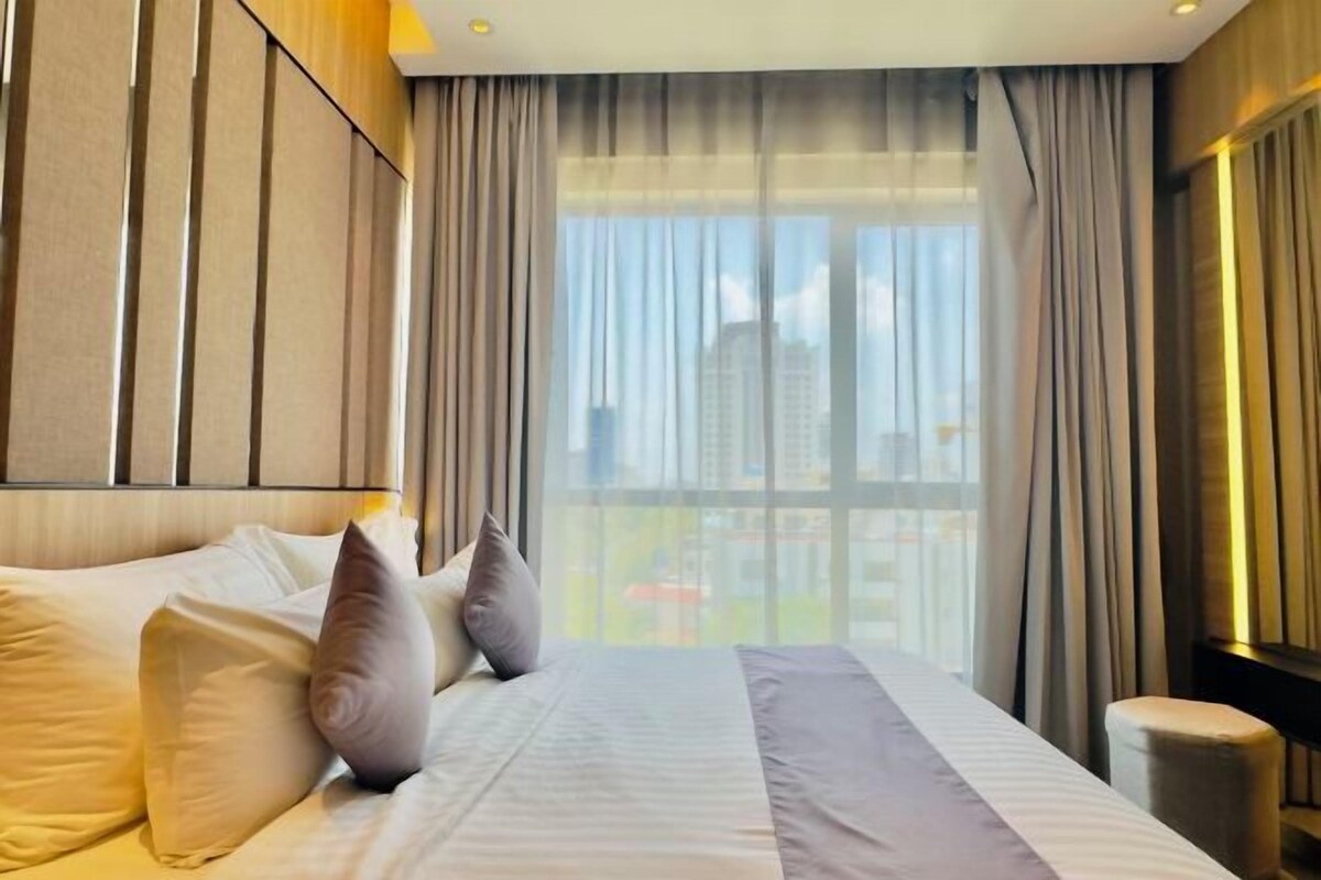 A hotel room with a large bed, a view of the city, and a modern design.