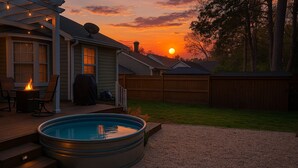 A backyard with a swimming pool, a deck with chairs and a fire pit, and a wooden fence. - Few Mins to Ballantyne-Pet Friendly-1 Level Home-Private Plunge Pool in Backyard (Pineville)