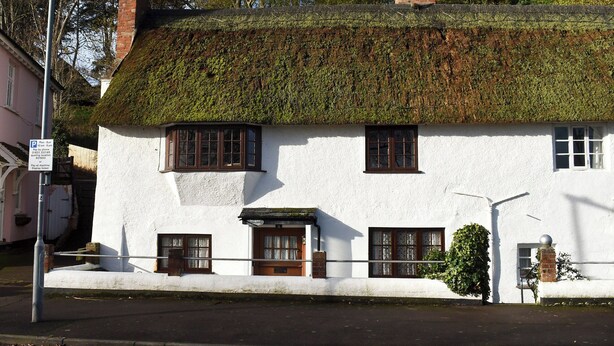 A traditional white building with a thatched roof, multiple windows, and a visible chimney. - Perfect for couples and familes to come and enjoy the local area. (Minehead)
