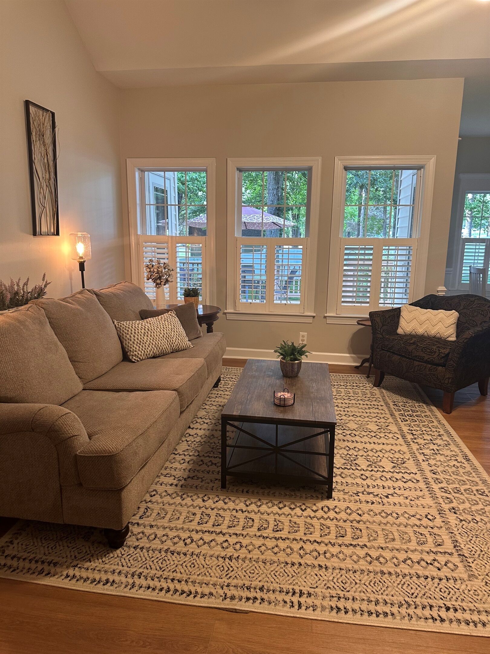A living room with a sofa, a coffee table, and a patterned rug.