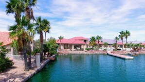 A resort with a pool, palm trees, and buildings with red roofs. - Gorgeous 5-Star Home on the Lake, near Laughlin/Bullhead Casinos & Lake Mohave (Bullhead City)