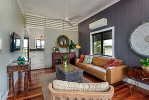 A living room with a sofa, coffee table, and a television. - `Kookaburra` at Savannah House (Westcourt)