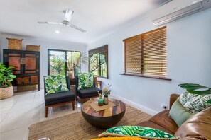 A living room with a round coffee table, two sofas, a ceiling fan, and a window with blinds. - `Wallaby` at Savannah House (Westcourt)