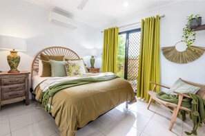 A bedroom with a bed, bedside tables, a chair, and a window with curtains. - `Wallaby` at Savannah House (Westcourt)