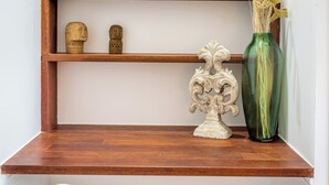 Une étagère en bois ornée d’objets décoratifs, notamment un vase et une sculpture.