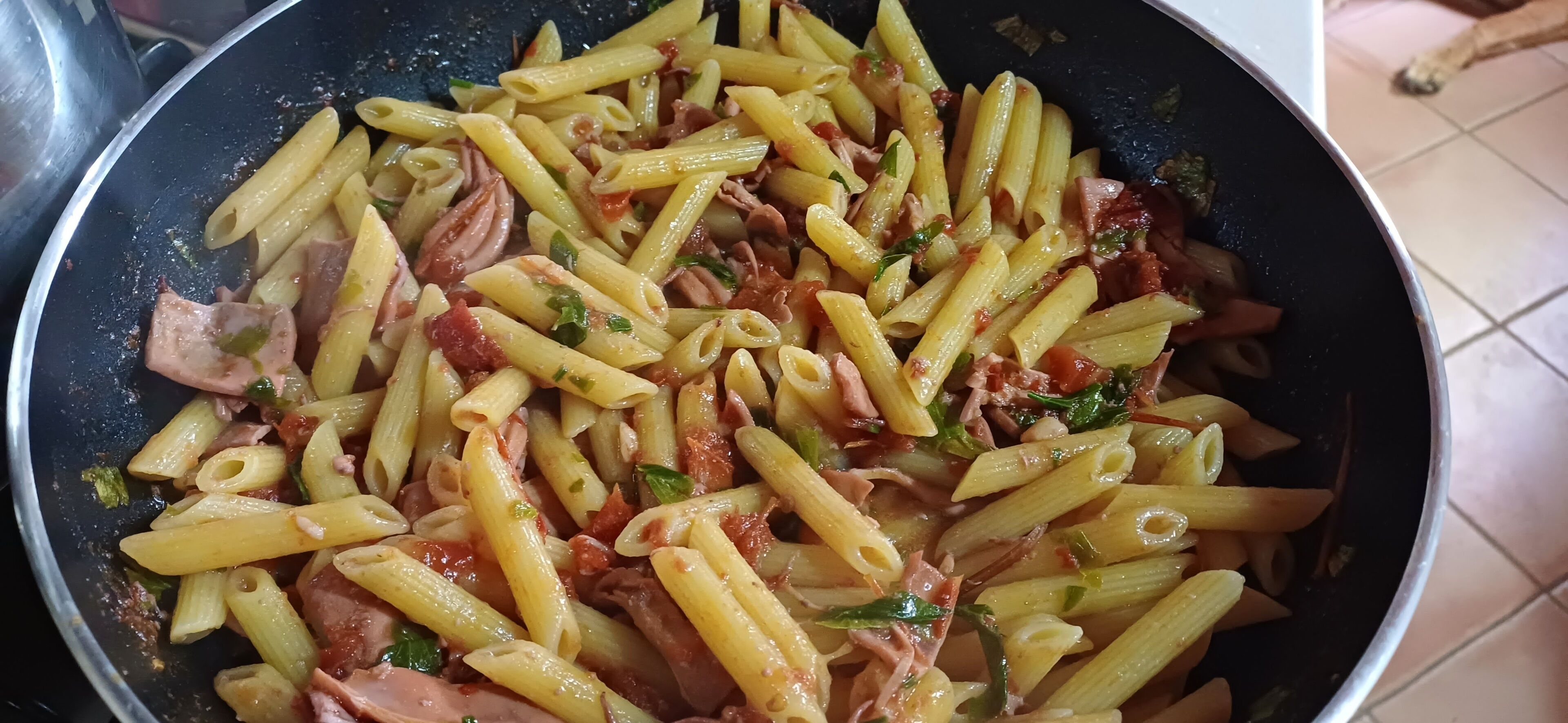 Une poêlée de pâtes au jambon et aux légumes.