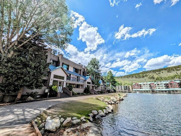 A lakeside hotel with multiple buildings, a stone pathway, and a view of the lake. - Argentine 1504 (Keystone)