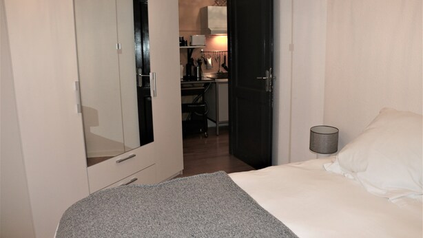 Une chambre d’hôtel avec un lit, un bureau et une kitchenette.