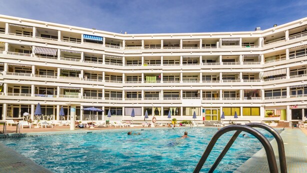 Ett hotell med flera våningar och en swimmingpool.