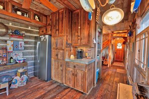 Kitchen features a wooden countertop, stainless steel refrigerator, and a coffee maker.