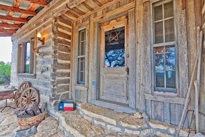Experience a traditional cabin with a stone foundation, wooden logs, and a front door adorned with a decorative star.