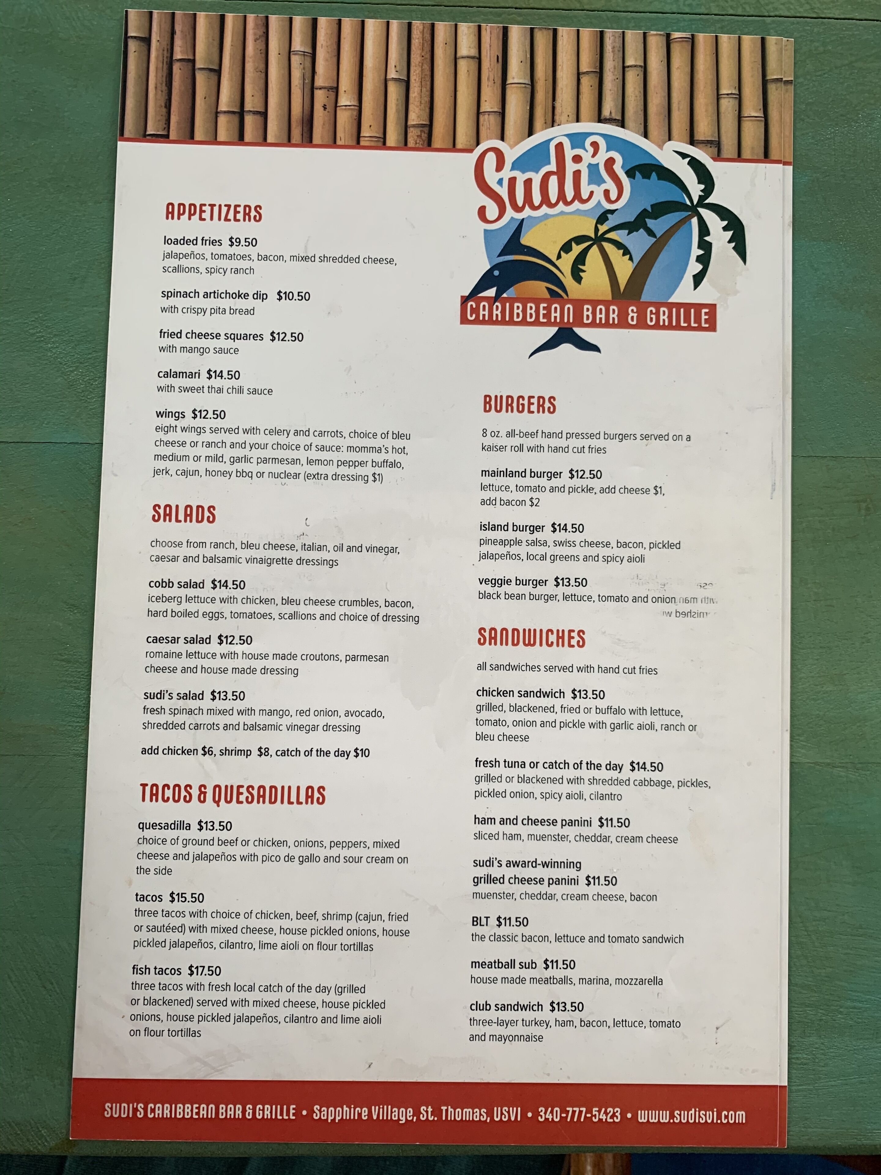 A menu from Sudi's Caribbean Bar & Grille listing various dishes and their prices.