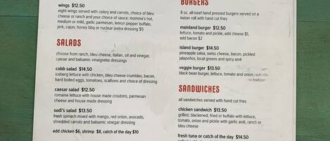A menu from Sudi's Caribbean Bar & Grille listing various dishes and their prices.