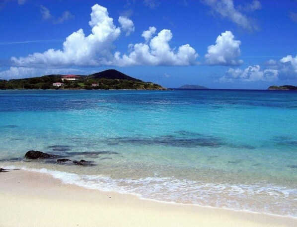 Enjoy a serene beach experience with clear turquoise waters and a sandy shore.