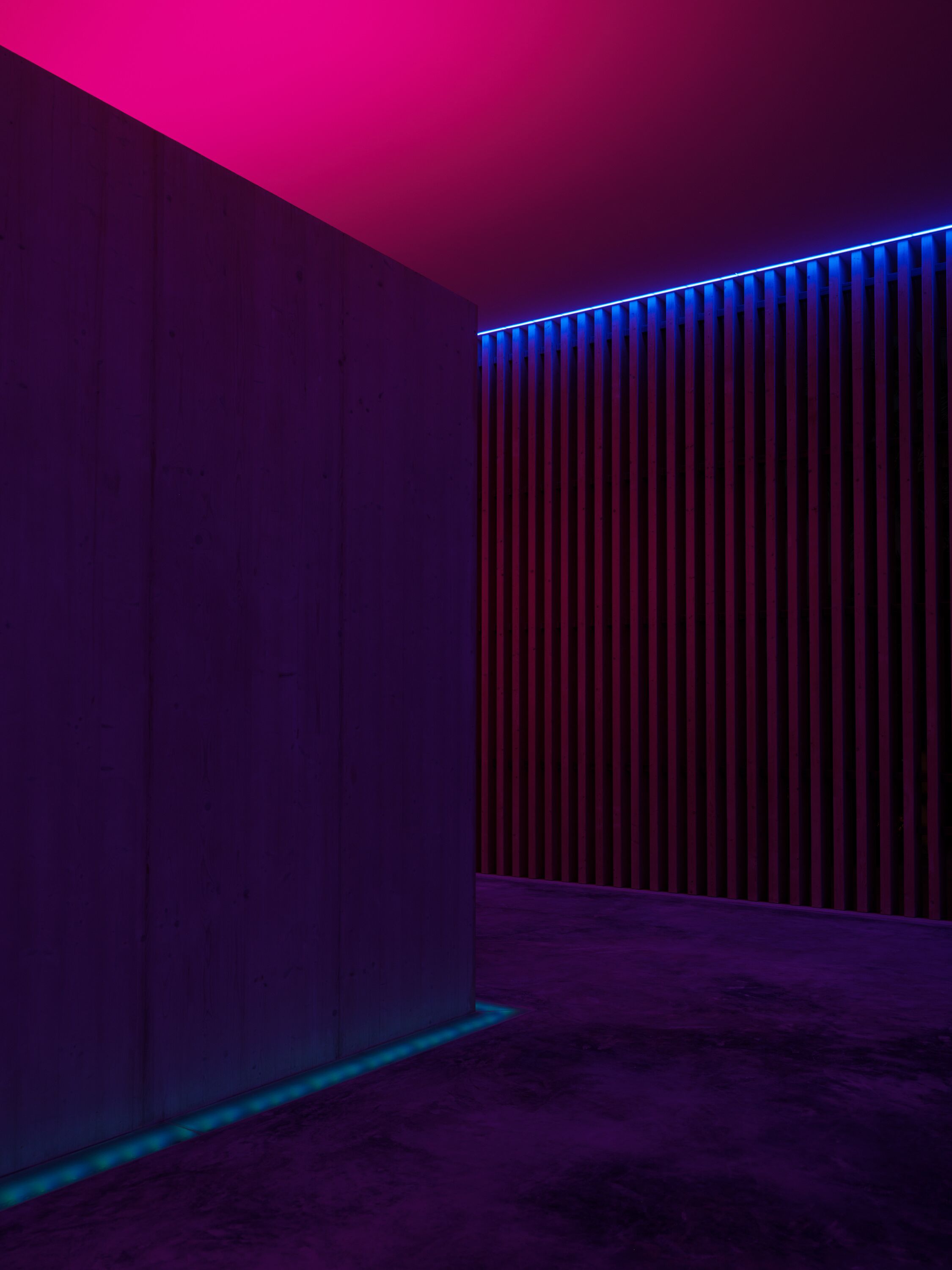 Una habitación con pared de paneles de madera y una tira de luz vertical.