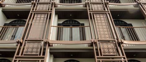 Fachada de hotel con varios balcones, amplias ventanas y un letrero que dice 'Sanae Old Town Hotel'.