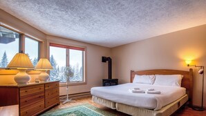Ein Schlafzimmer mit Bett, Kommode, Lampe und Heizung.