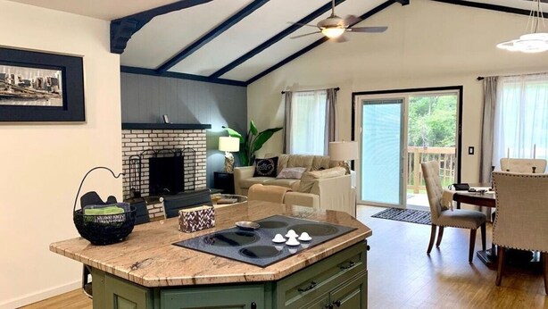 A spacious kitchen with a large island, a fireplace, and a dining area with a table and chairs.