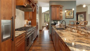 A spacious kitchen with wooden cabinets, a granite countertop, and a built-in stove. - 555 Independence Road by Summit County Mountain Retreats (Keystone)