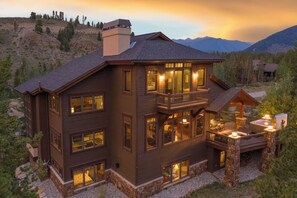 A multi-story house with a balcony, large windows, and a stone foundation. - 671 Elk Circle by Summit County Mountain Retreats (Keystone)