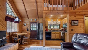 L’intérieur d’une cabane en bois comprend un coin repas, une cuisine et un salon.