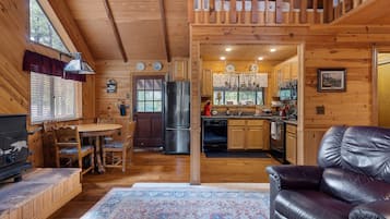 L’intérieur d’une cabane en bois comprend un coin repas, une cuisine et un salon.