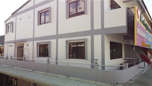 A multi-story building with a flat roof and a balcony. - OYO 75377 Check In House (Surat Thani)