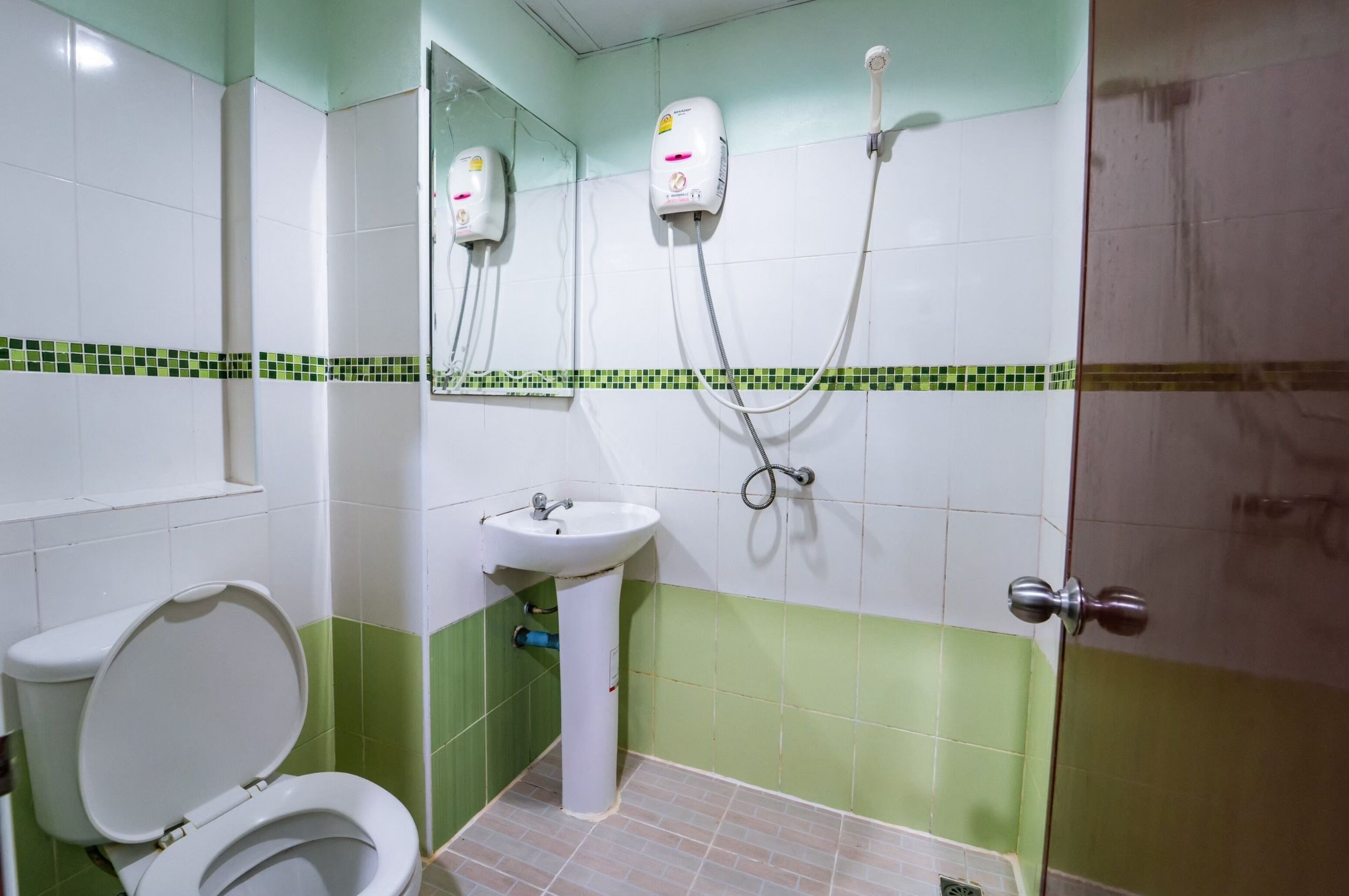 Une salle de bain comprenant des toilettes, un lavabo et une douche.