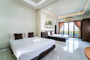 A hotel room with a large bed, a smaller bed, a vanity with a mirror, and a balcony with curtains. - OYO 75377 Check In House (Surat Thani)