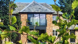 Un bâtiment en briques de deux étages, doté de grandes fenêtres et d’un toit en pente.