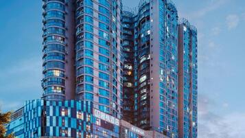 A high-rise hotel with multiple balconies, a prominent entrance, and a large billboard.