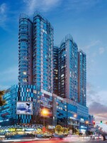 A high-rise hotel with multiple balconies, a prominent entrance, and a large billboard.
