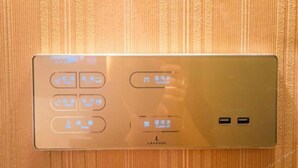 Un panel de control con varios botones e indicadores, probablemente para los servicios de la habitación.