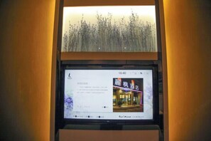 A digital display with a clock showing 16:40, a restaurant sign, and a decorative wall with a plant. - Lavande Hotel (Guangyuan Wanda Plaza Olympic Center) (Guangyuan)