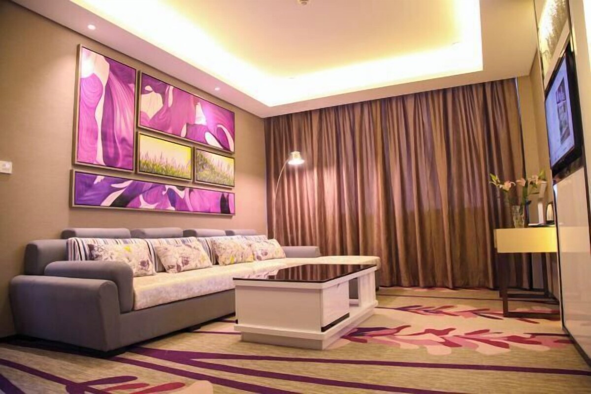 A modern living room with a sofa, a coffee table, and a TV mounted on the wall.