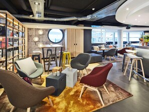 A modern interior with a bar area, seating, and a view of the city. - Radisson Hotel Paris Le Bourget (Bonneuil-en-France)