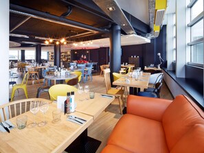 A restaurant with multiple dining tables and chairs, some with wine glasses and cutlery. - Radisson Hotel Paris Le Bourget (Bonneuil-en-France)