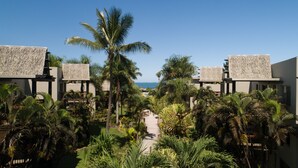 A resort with multiple buildings, palm trees, and a pathway leading to the beach. - Club Wyndham Denarau Island, Trademark Collection by Wyndham (Nadi)