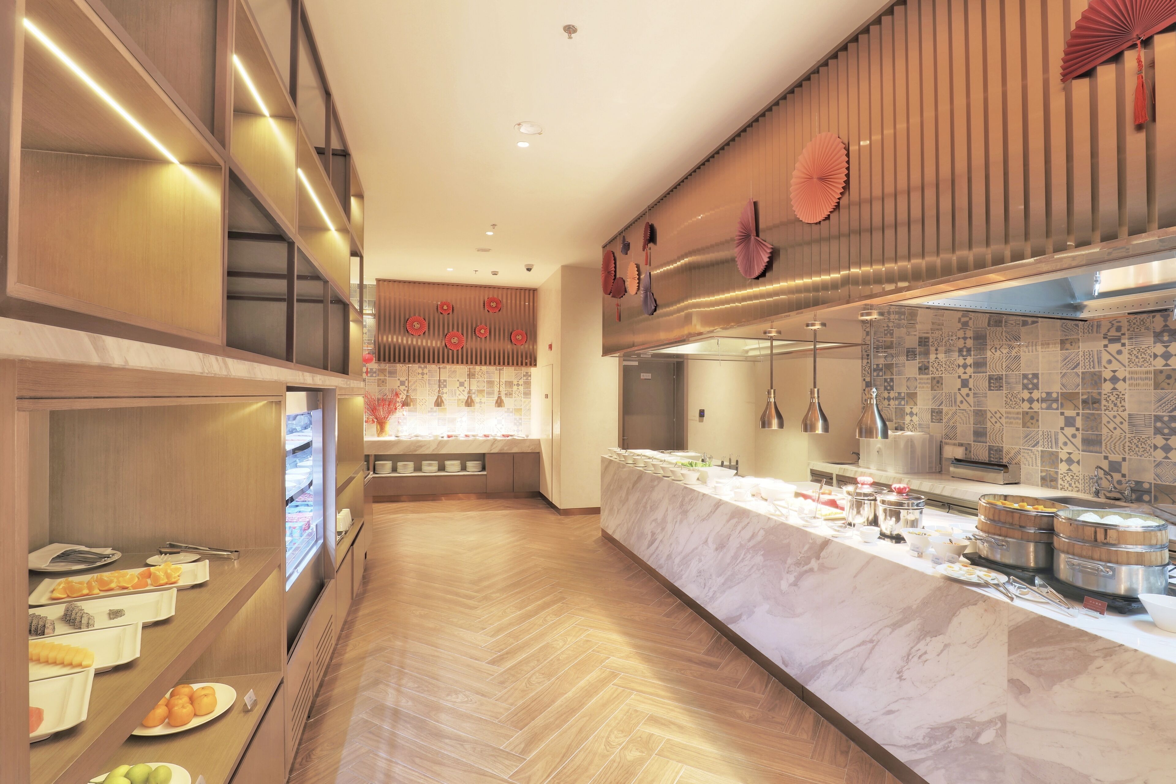 A hotel breakfast area with a marble counter, buffet with various food items, and decorative elements like fans and lanterns.